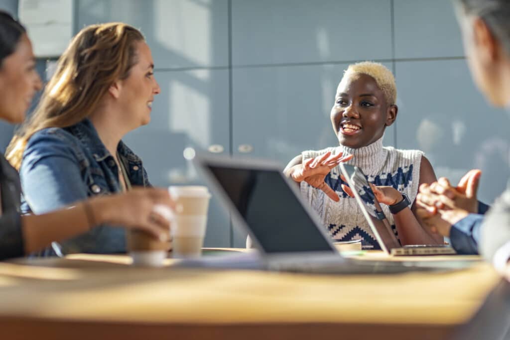 Smiling young business people are talking in a meeting.