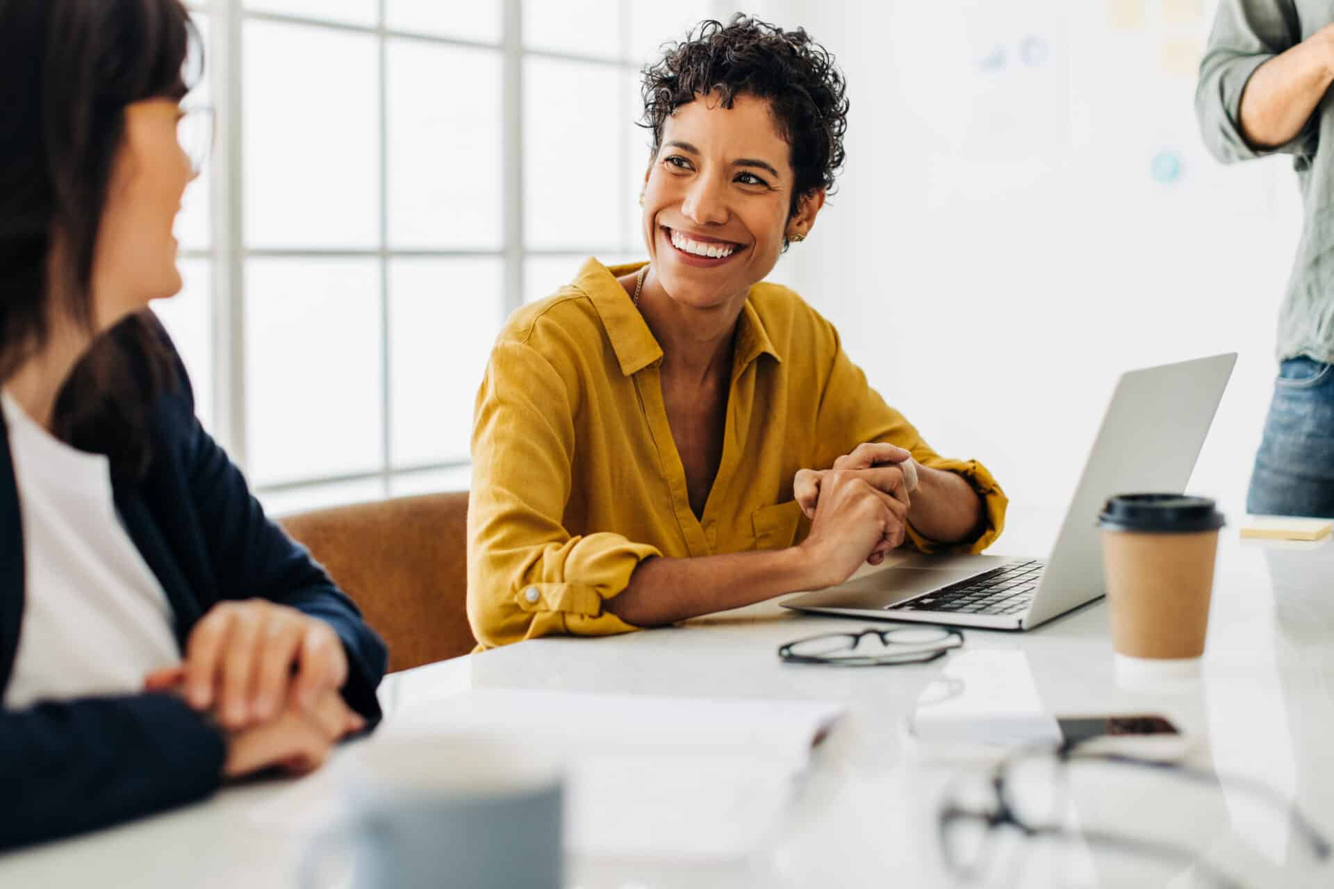 A smiling business woman is getting started with Babbel for Business on her laptop in an office.