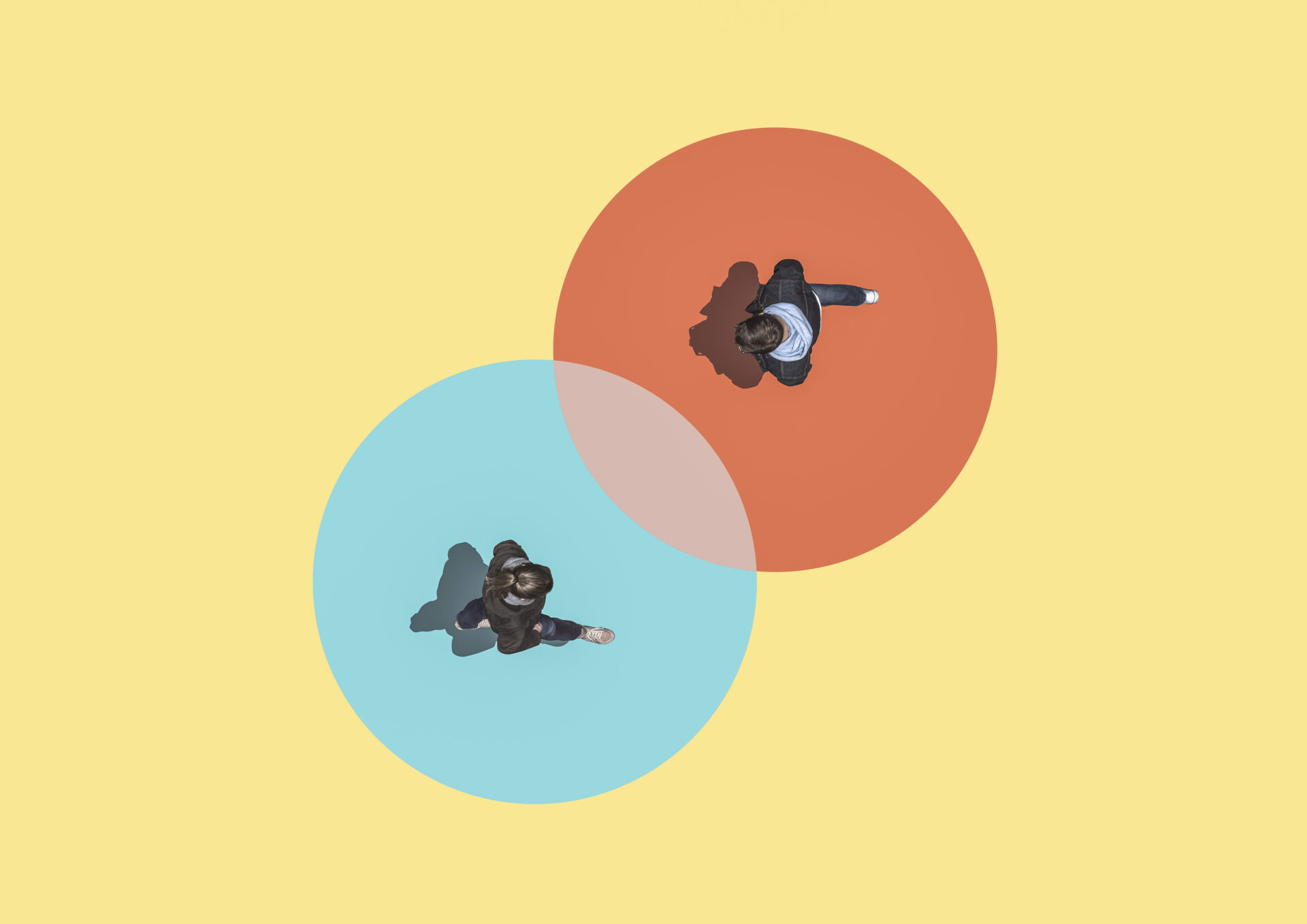 Collage mit zwei Menschen aus der Vogelperspektive, die von zwei Kreisen umgeben sind und sich annähern; als Symbol für ein bevorstehendes Mitarbeitergespräch.