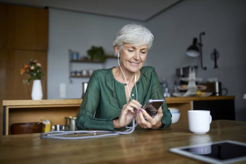 Lächelnde Frau benutzt ihr Smartphone.