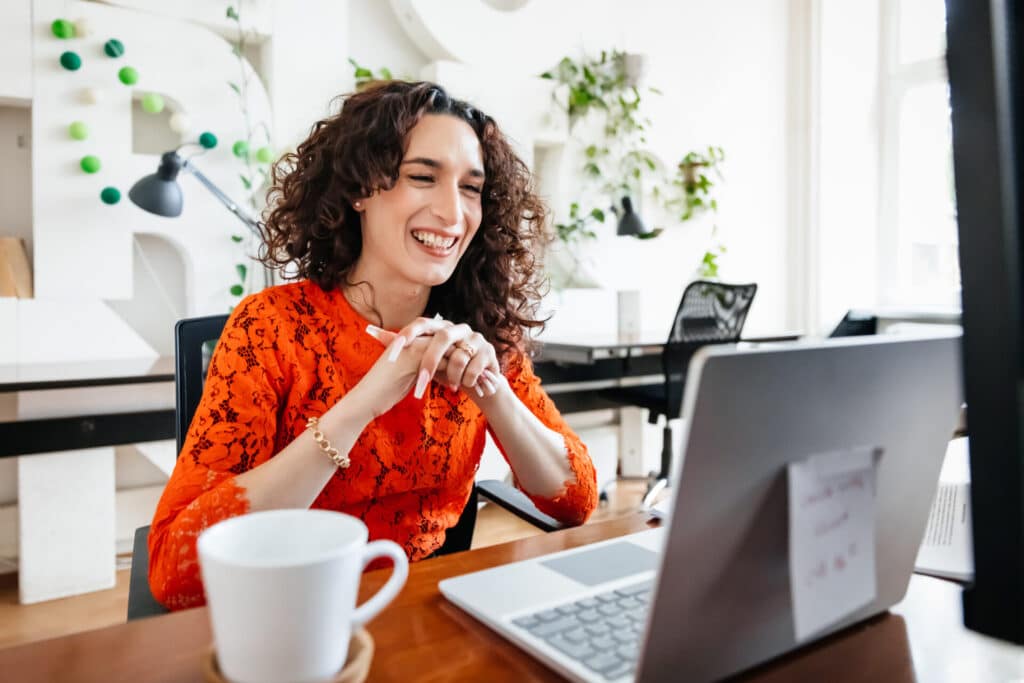 Smiling business woman is learning a new language on her computer.