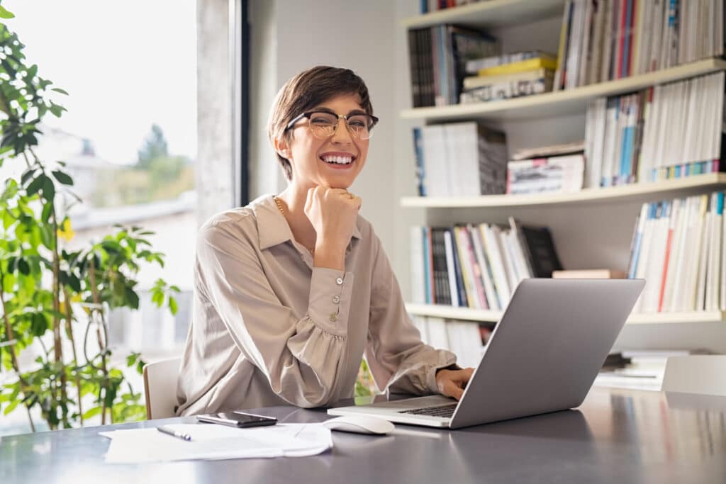 Lächelnde Geschäftsfrau arbeitet an ihrem Laptop.