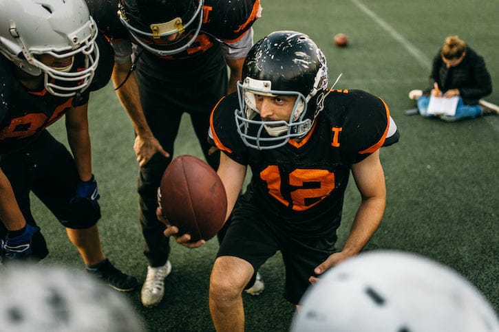 A football sports team is talking about their strategy on the field.