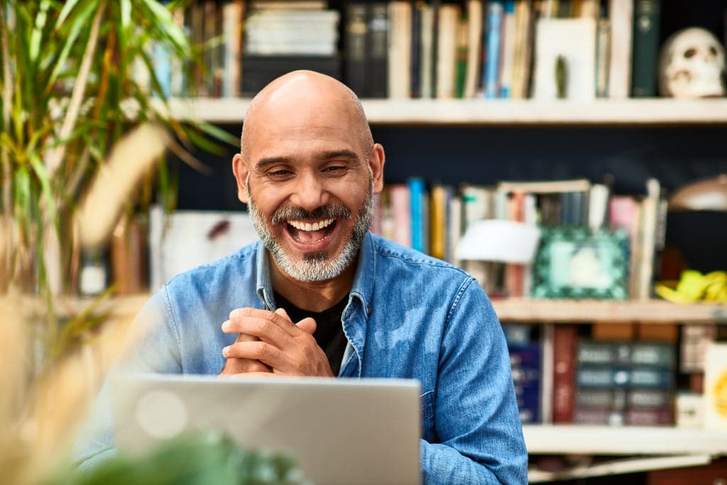 Smiling business man is working on his laptop.