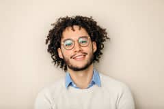 Smiling office worker standing in front of a wall.