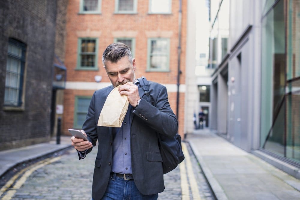 Man eating and working at the same time