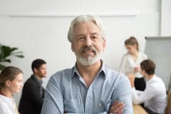 Smiling business man standing in a meeting.