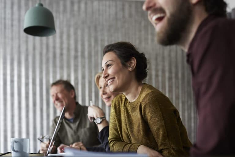 Happy co-workers feel safe to talk in a meeting.