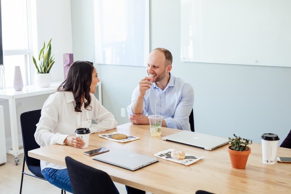 Zwei Mitarbeiter:innen haben ein Gespräch im Büro.