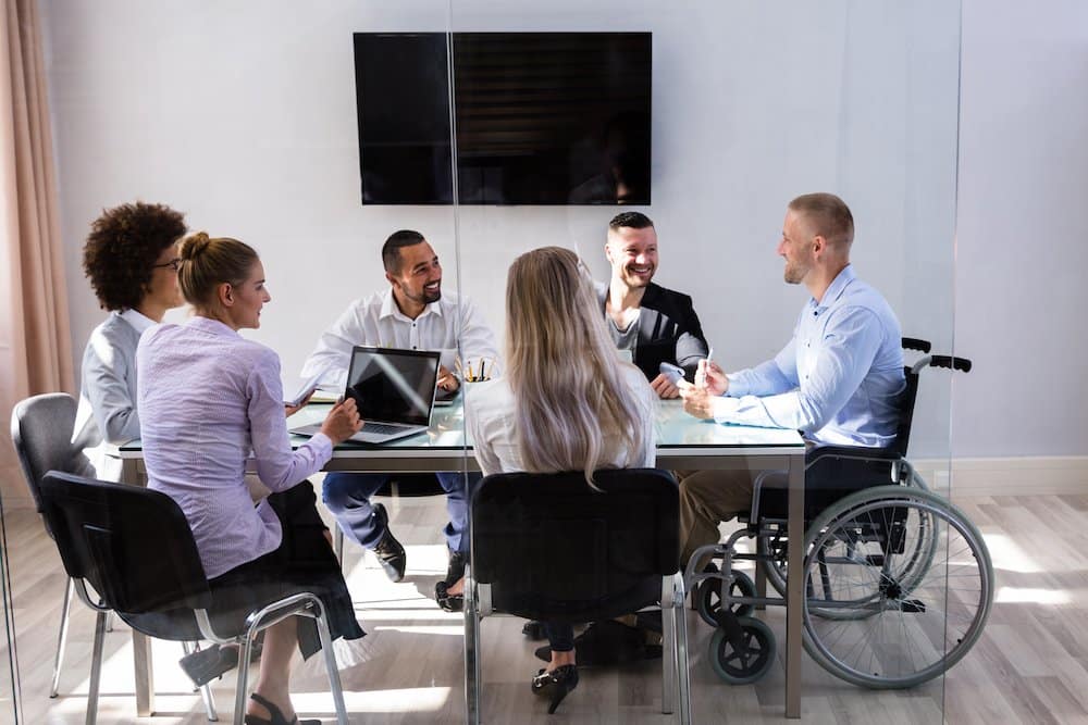 Eine diverse Arbeitsgruppe unterhält sich in einem Meeting im Büro.