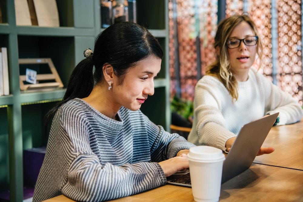 Zwei Kolleginnen lernen mit Blended Learning auf ihrem Laptop.