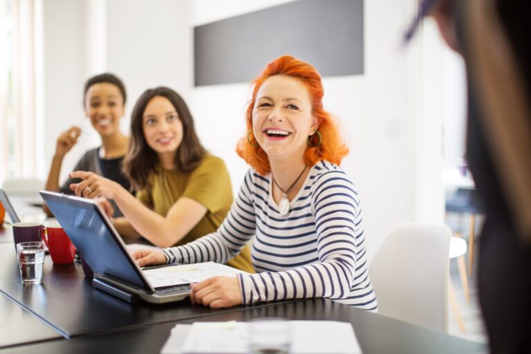 Lächelnde Geschäftsfrau bespricht in einem Meeting die aktuellen HR-Trends.