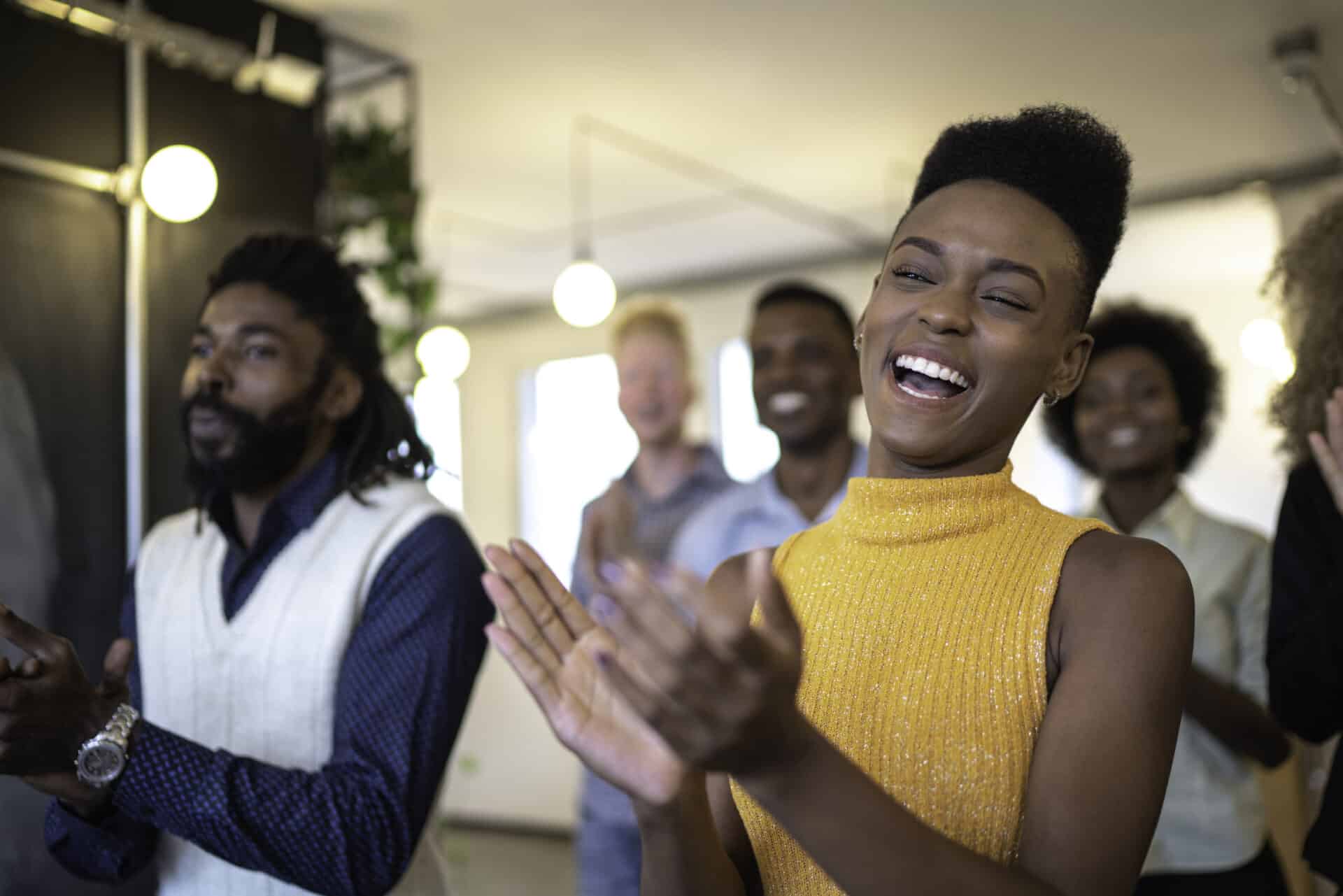 Lächelnde Mitarbeiter:innen klatschen in die Hände nachdem sie eine positive Employee Experience hatten.