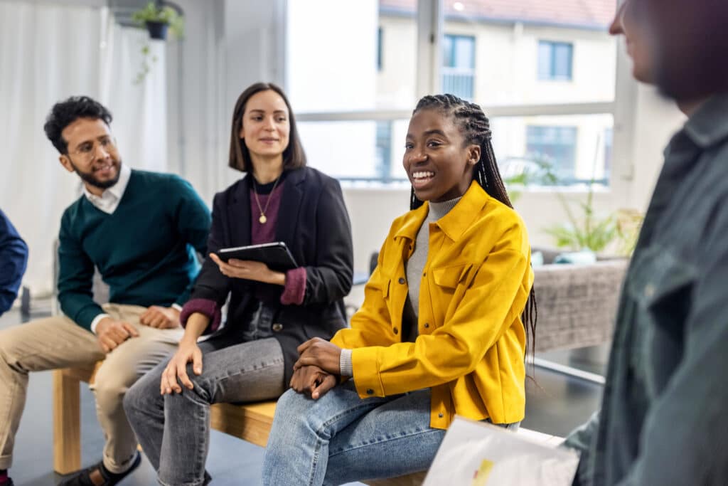 Happy young business people are talking about talent development in a meeting.