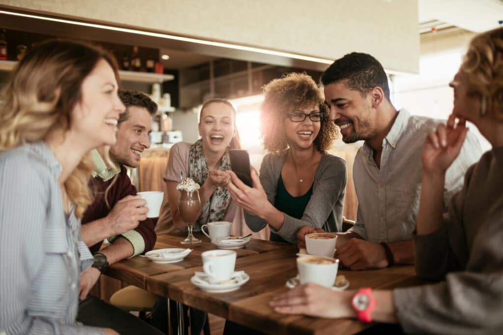 Smiling, happy people are chatting in a cafe.