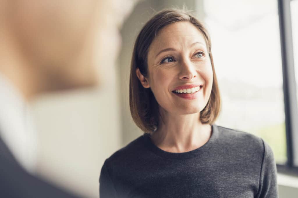 Smiling business woman is talking with colleagues in an office.