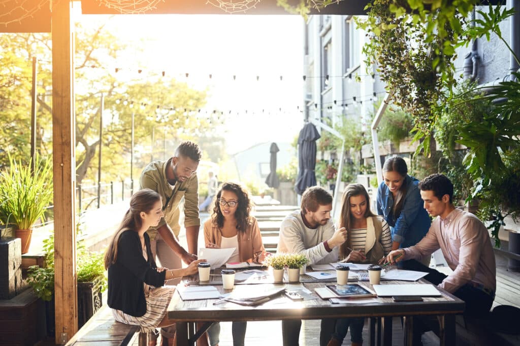 A group of young business people is working in an cafe, because they have flexible work arrangements.