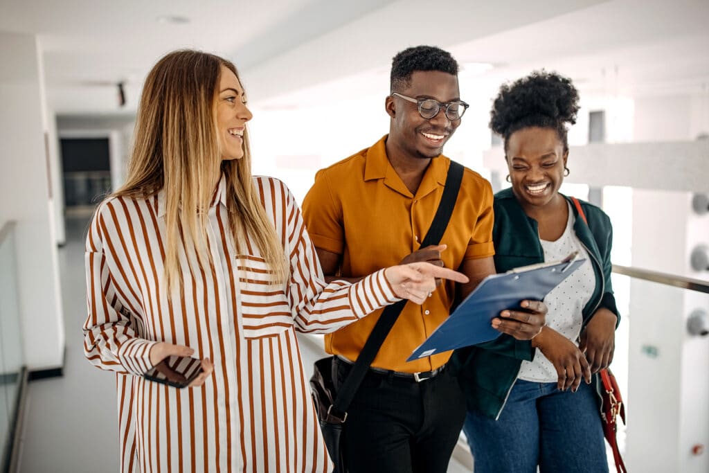 Three young business people are discussing a project that they are self-managing.