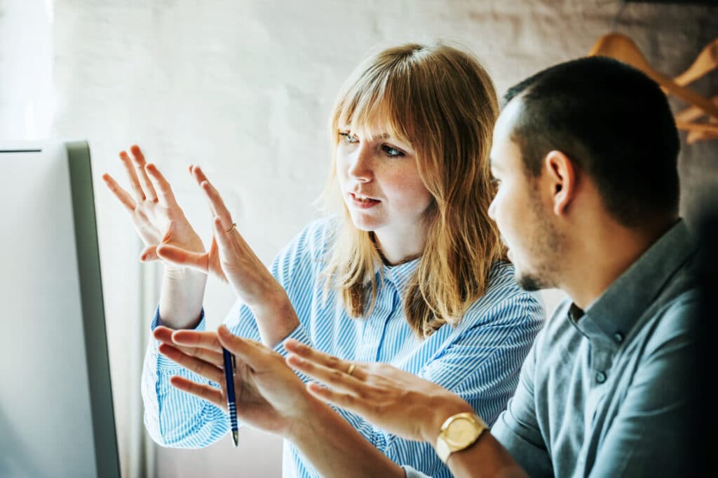 Two young business people are discussing a project that they are self-managing.