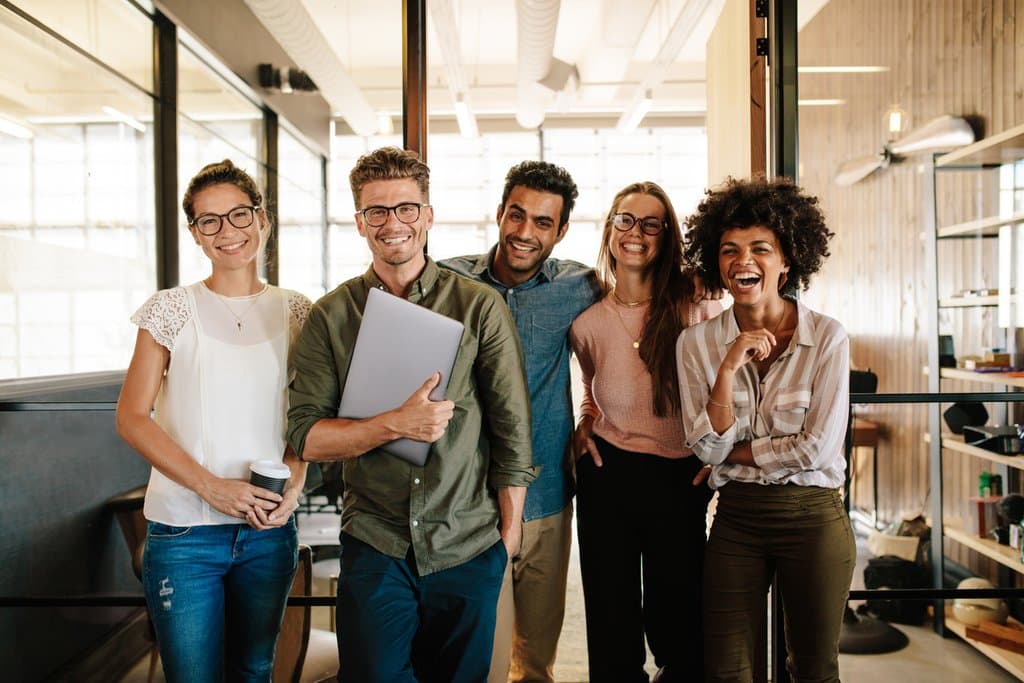 Young business people are smiling and talking in an office.