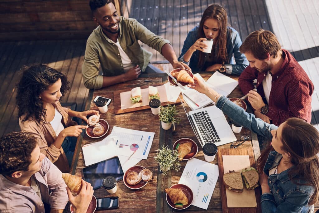 Young business people are having lunch while working.