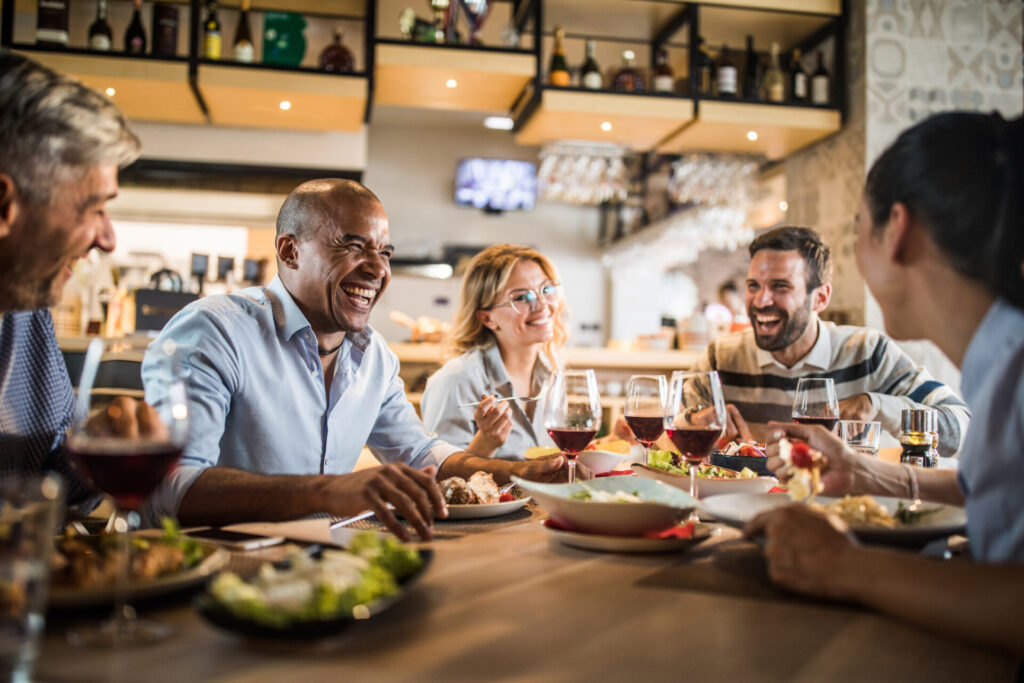 Happy customers in a restaurant are laughing and talking together.
