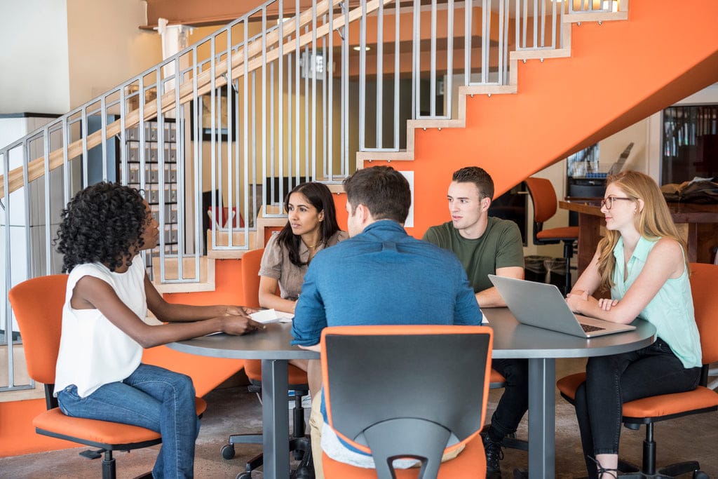 Young employees learning languages together at a cafeteria.