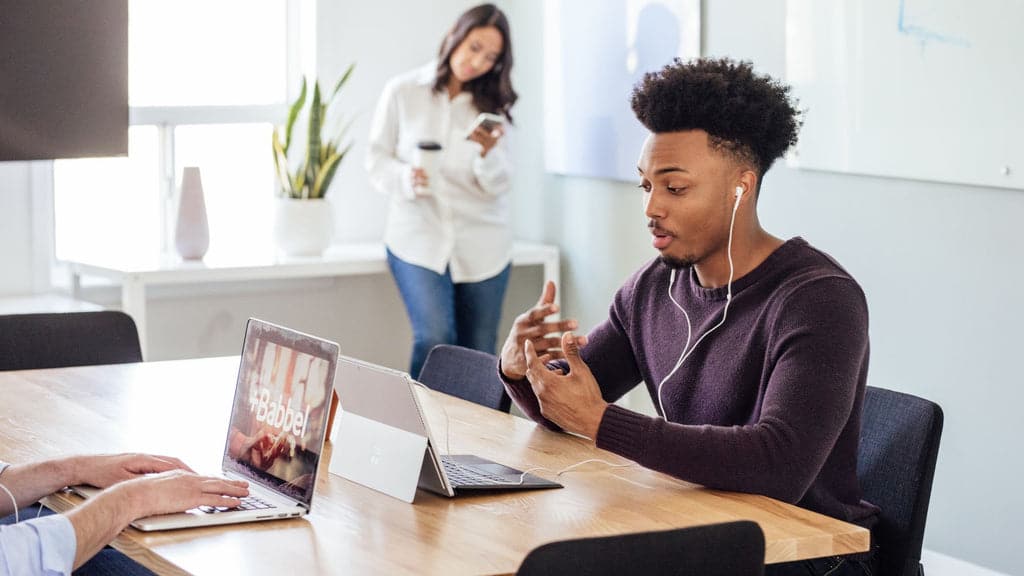 Photo of language learning employees of a company using Babbel in the office with desktop and smartphone app